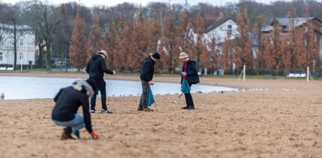 Menschen reinigen einen Strand im Freien.