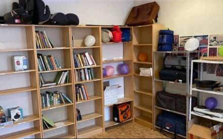 Regale mit Büchern und verschiedenen Gegenständen, darunter Ballons.